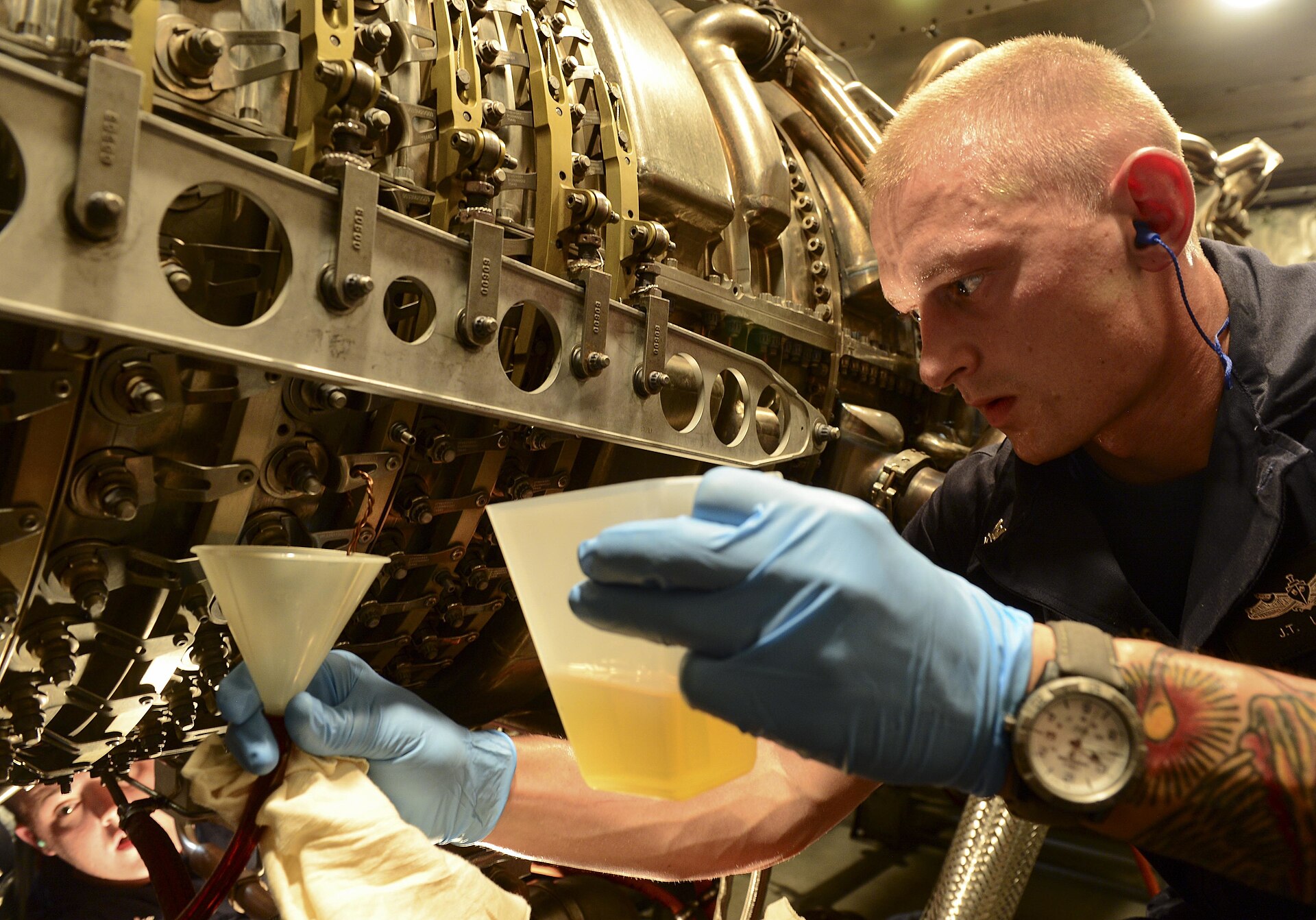 Navy technician performing engine maintenance on a U.S. warship